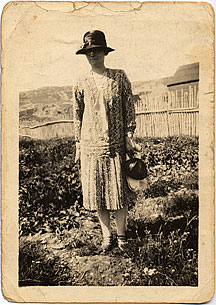 Bertha Davis stands near her parents home in Clown's Cove