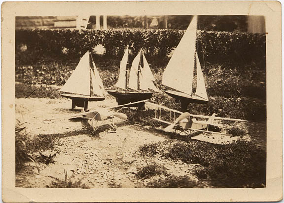 Hand made wooden models of a schooner, sail boat, biplane and airplane