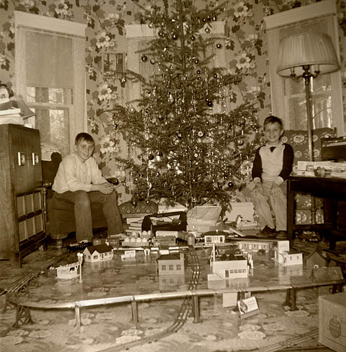 1958 Kenny and a friend play with the train at Christmas