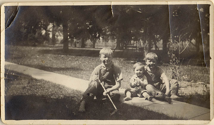 Walter, Claude and Willard hang out on the sidewalk on the Otesgo farm in about 1920.