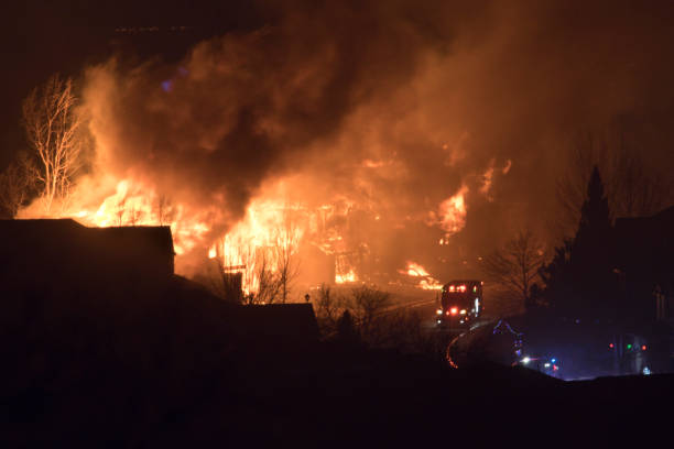 Rolling past the inferno, a fire engine is overwhelmed by the massive flames.